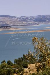 Image du Maroc Professionnelle de  Le barrage Oued El Makhazine, conçu pour le développement et  l'irrigation du périmètre du Loukkos. Ainsi les champs situés dans le triangle Ksar El Kébir, Larache, Moulay Bouselham profitent de cette infrastructure. Cette importante réalisation située sur El Oued Loukkos sert à la régularisation inter annuelle des débits tout en formant une protection contre les crues, au Jeudi 1er Septembre 2005 à cette datte le barrage dispose 309 Million de M3. (Photo / Abdeljalil Bounhar)